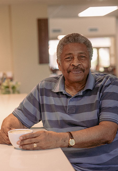 Senior man at counter top with coffee in hand