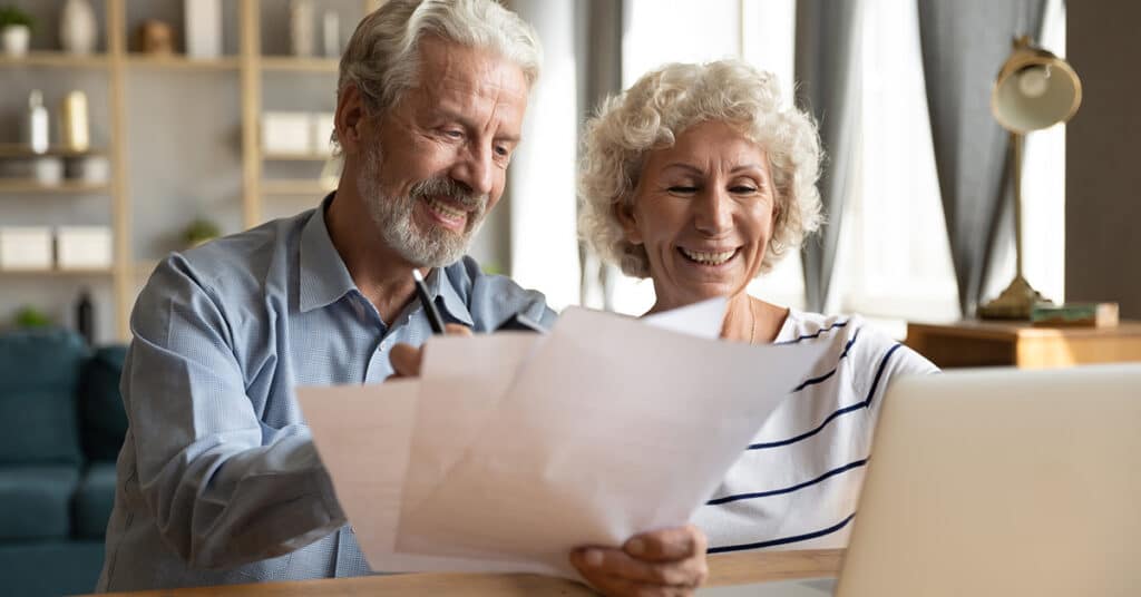 Couple at desk comparing costs of senior living.