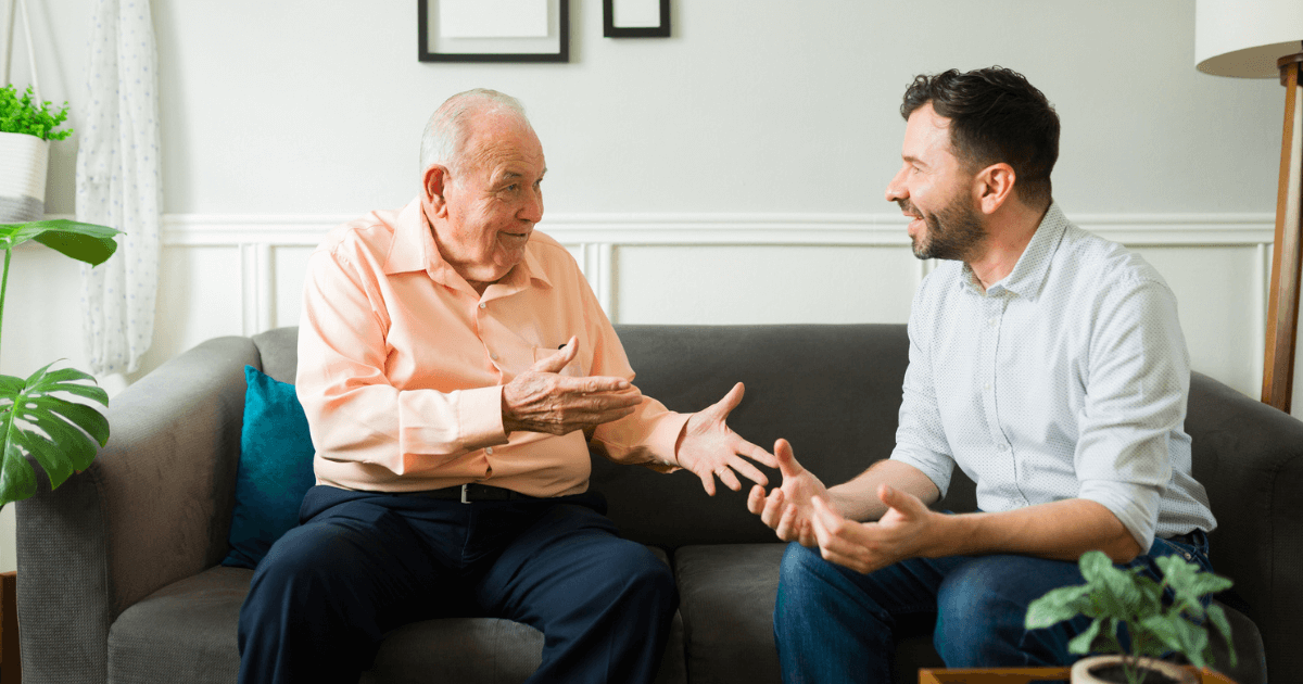 Senior man speaking to middle aged man about assited living