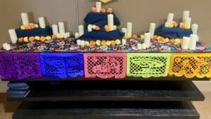 a typical Dia de los Muertos ofrenda altar with candles and flowers