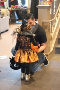 Little girl dressed as orange witch trick or treating